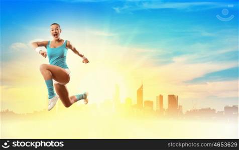 Image of sport woman jumping. Image of sport girl in jump against city background