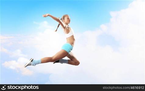 Image of sport woman jumping. Image of sport girl in jump against cloudy background