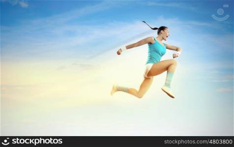 Image of sport woman jumping. Image of sport girl in jump against cloudy background