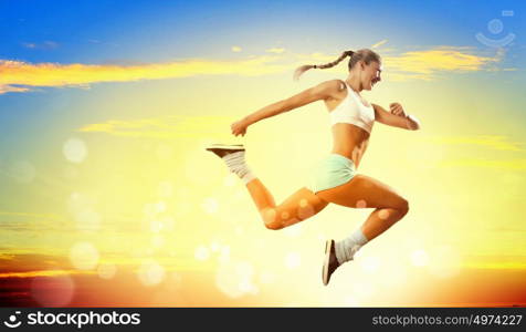 Image of sport woman jumping. Image of sport girl in jump against cloudy background