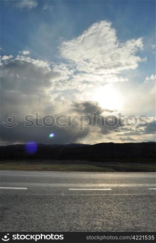 Image of sun shine through rain cloud at sunset