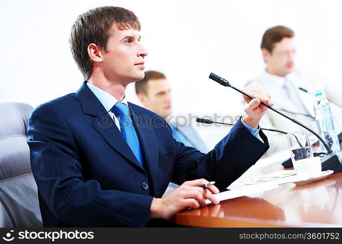 Image of three businesspeople at table at conference