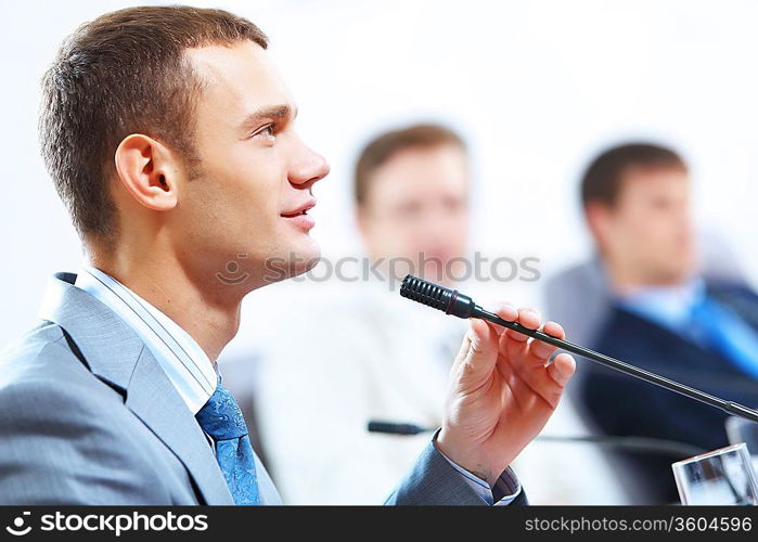 Image of three businesspeople at table at conference