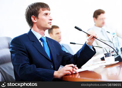 Image of three businesspeople at table at conference