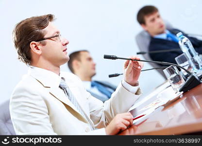 Image of three businesspeople at table at conference