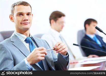 Image of three businesspeople at table at conference