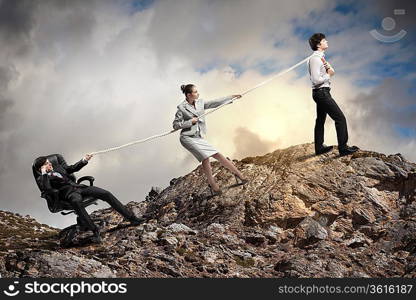 Image of three businesspeople pulling rope atop of mountain