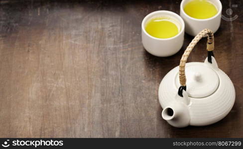 Image of traditional eastern teapot and cups on rustic background