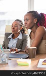 Image of two african businesswomen interacting at office