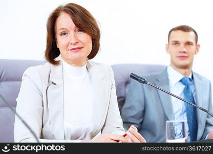 Image of two businesspeople sitting at table at conference