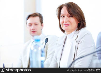 Image of two businesspeople sitting at table at conference