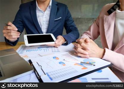 Image of two young businessmen partners looking at business document in touchpad at meeting office.