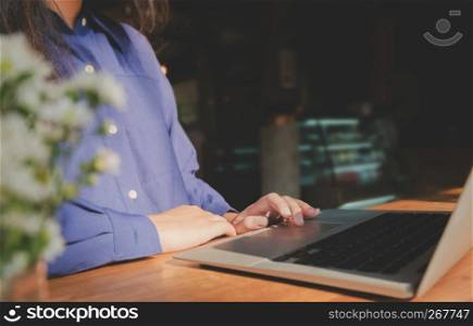 image of woman hands using / typing on laptop computer selected focus on keyboard