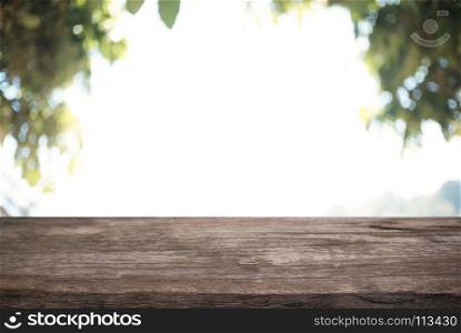 Image of wood table in front of abstract blurred background of outdoor garden lights. can be used for display or montage your products.Mock up for display of product