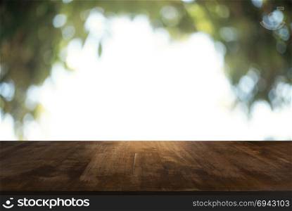 Image of wood table in front of abstract blurred background of outdoor garden lights. can be used for display or montage your products.Mock up for display of product