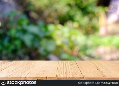 image of wooden table in front of abstract blurred background of outdoor garden lights. can be used for display or montage your products.Mock up for display of produc