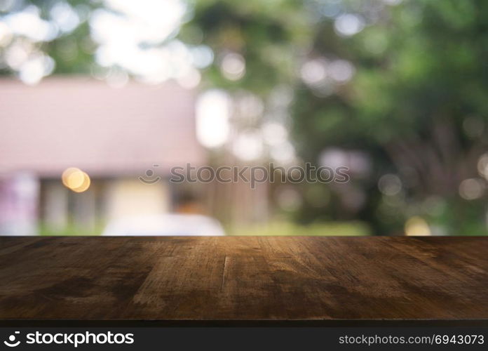 image of wooden table in front of abstract blurred background of outdoor garden lights. can be used for display or montage your products.Mock up for display of product