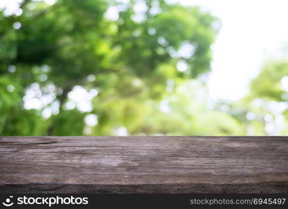Image of wooden table in front of abstract blurred background of outdoor garden lights. can be used for display or montage your products.Mock up for display of product.