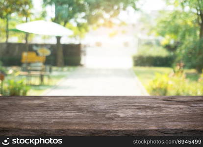 Image of wooden table in front of abstract blurred background of outdoor garden lights. can be used for display or montage your products.Mock up for display of product.