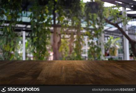 image of wooden table in front of abstract blurred background of outdoor garden lights. can be used for display or montage your products.Mock up for display of product