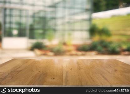 image of wooden table in front of abstract blurred background of outdoor garden lights. can be used for display or montage your products.Mock up for display of product.