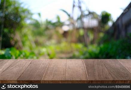 image of wooden table in front of abstract blurred background of outdoor garden lights. can be used for display or montage your products.Mock up for display of product