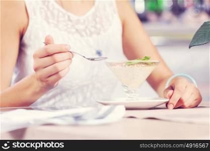 Image of young and pretty woman having dessert in cafe