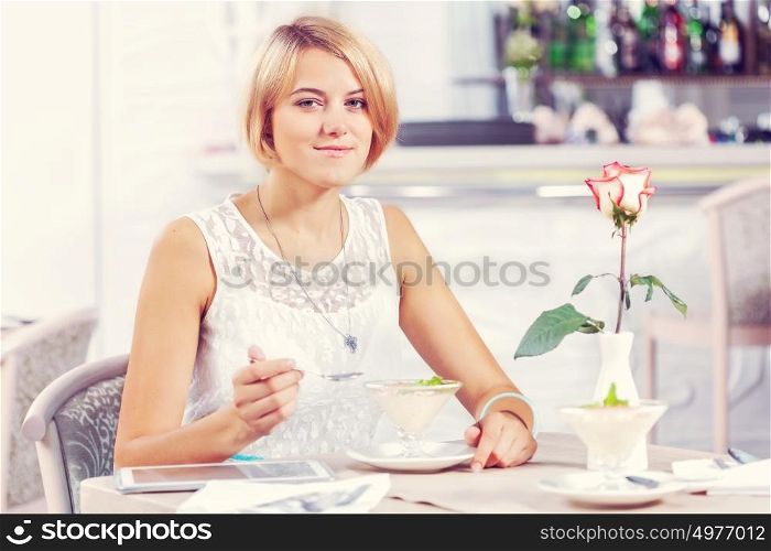 Image of young and pretty woman having dessert in cafe. This is super delicious