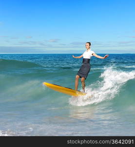 Image of young business person surfing on the waves of the ocean