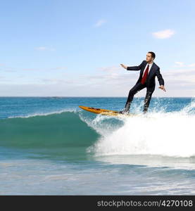 Image of young business person surfing on the waves of the ocean