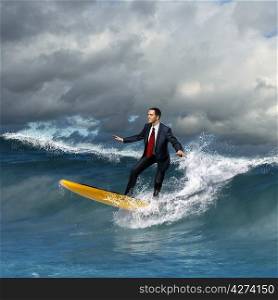 Image of young business person surfing on the waves of the ocean
