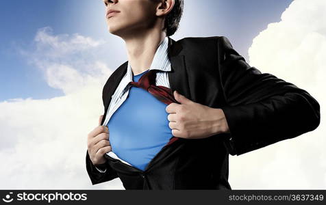Image of young businessman showing superhero suit underneath his shirt