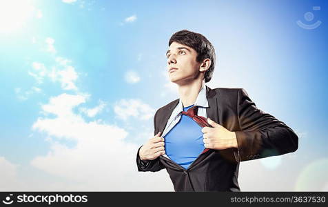 Image of young businessman showing superhero suit underneath his shirt