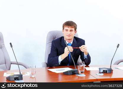 Image of young businessman sitting at table at business meeting