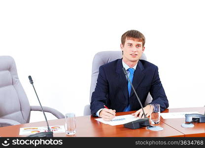 Image of young businessman sitting at table at business meeting