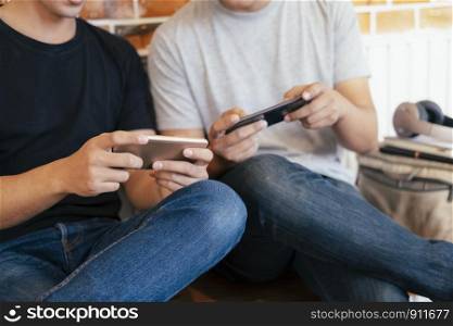 Image of young men playing together and competing in video games on smartphones.