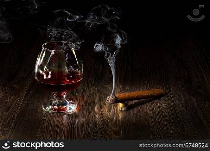 Image with a glass of cognac and cigar