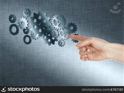 Image with machinery gears and human hand