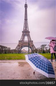 Image with the Eiffel tower and an umbrella in foreground on a rainy day of February, in Paris, France.