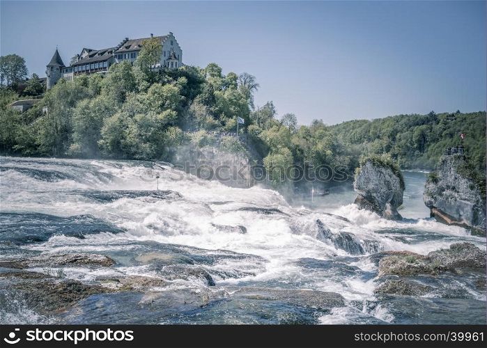 Image with the Laufen Castle on a hill and the Rhine river at its feet. Picture captured in Switzerland, the municipality of Laufen-Uhwiesen