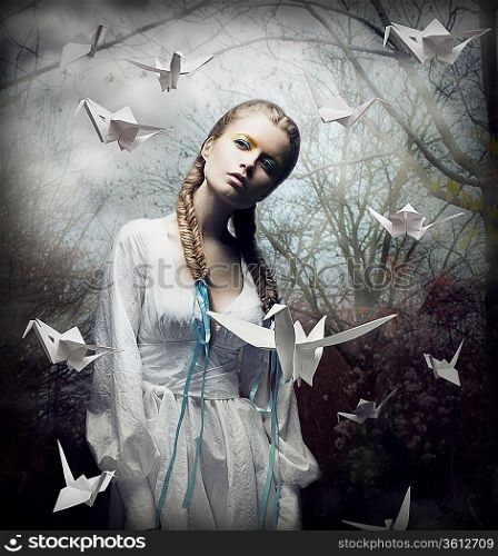Imagination. Romantic Blonde with Hovering Origami Birds in Spooky Forest. Magic