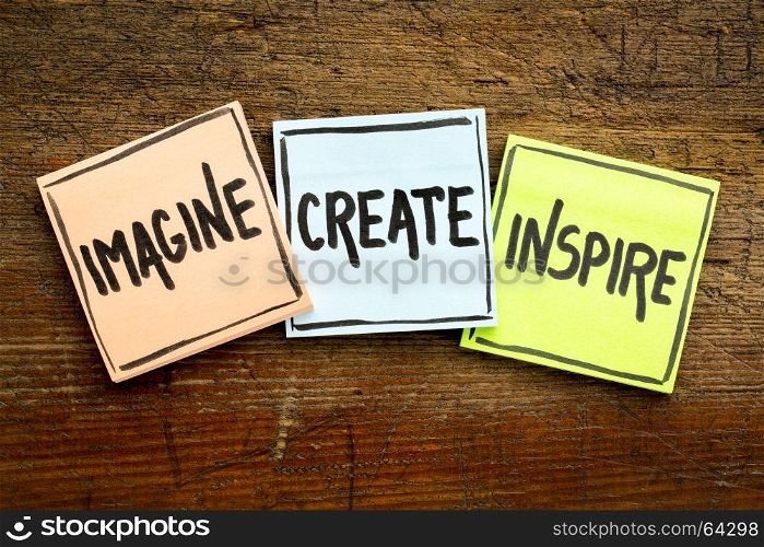 imagine, create, inspire concept - handwriting in black ink on sticky notes against rustic wood