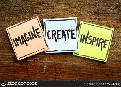 imagine, create, inspire concept - handwriting in black ink on sticky notes against rustic wood