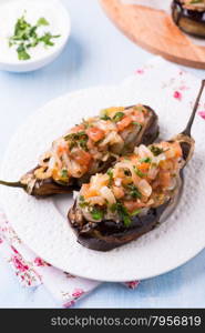 Imam Bayildi. Eggplants stuffed with vegetables on white plate. Turkish food. Slective focus. . Imam Bayildi. Eggplants stuffed with vegetables