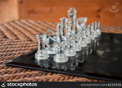 IMG_0491.JPG. Glass chess set on a black marble board placed on a rattan table