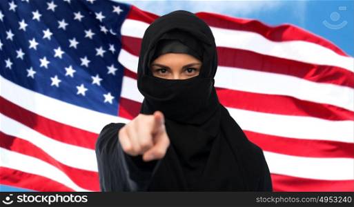 immigration and people concept - muslim woman in hijab pointing finger to you over american flagbackground. muslim woman in hijab pointing finger to you