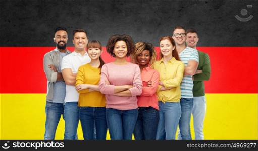 immigration, diversity, race, ethnicity and people concept - international group of happy smiling men and women showing thumbs up over german flag background. international group of happy smiling people