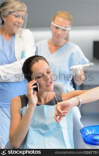 Impatient businesswoman patient on phone at dental clinic dentists waiting