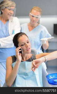 Impatient businesswoman patient on phone at dental clinic dentists waiting