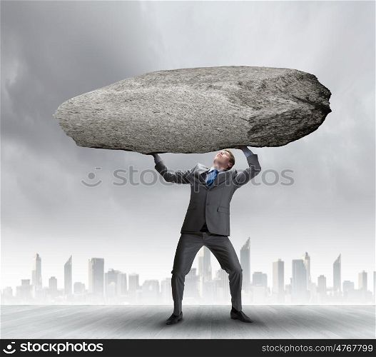 Impending problems. Powerful businessman holding huge stone above head